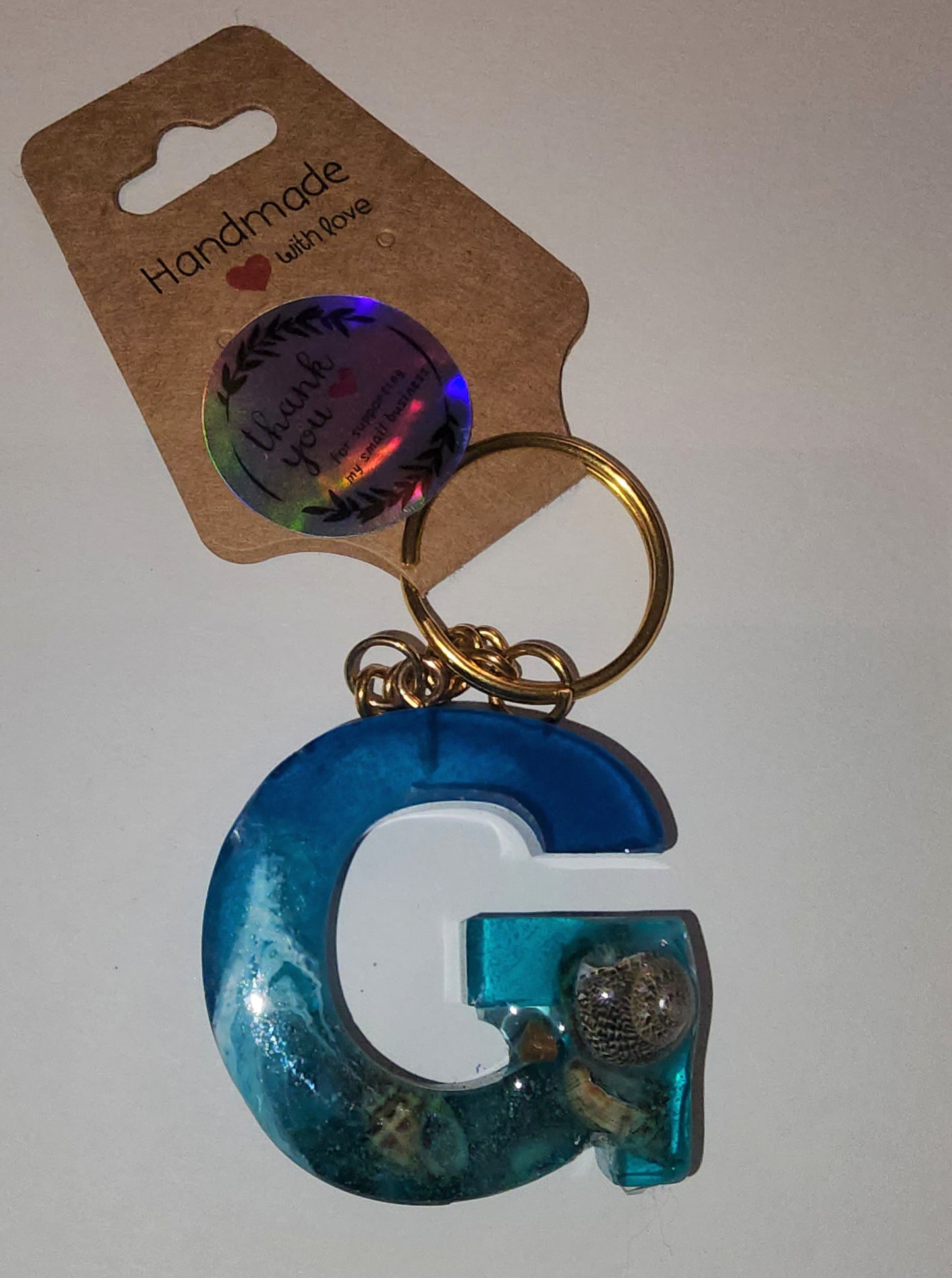 Epoxy alphabet keychains in various styles. I have  beach themes and mermaid colors. I have a few with rose pedals and gold flakes. All handmade by me and Locally handcrafted.